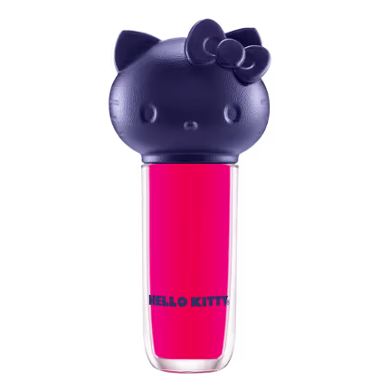 Produto de maquiagem em formato cilíndrico com a cabeça da personagem Hello Kitty como tampa. A parte superior é azul escuro com detalhes que representam os olhos, orelhas e laço da Hello Kitty. É possível ver a cor do produto pelo corpo transparente.