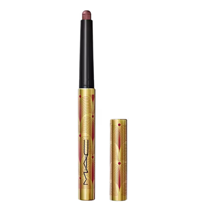 A imagem mostra uma sombra em bastão, em embalagem dourada, com detalhes vermelhos e logo da marca em preto. Ela está aberta, com a tampa ao lado.