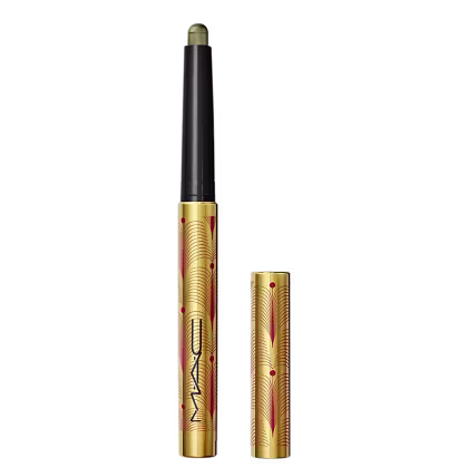 A imagem mostra uma sombra em bastão, em embalagem dourada, com detalhes vermelhos e logo da marca em preto. Ela está aberta, com a tampa ao lado.