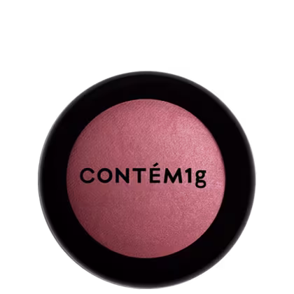 A imagem mostra uma embalagem fechada de blush. A embalagem é preta com parte transparente e o logo da marca em preto.