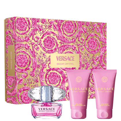 A imagem mostra um kit com o perfume Bright Crystal, shower gel e body lotion, da Versace. Ao fundo uma caixa com estampa floral.