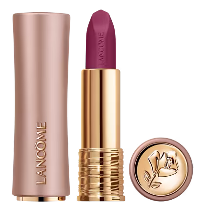 Produto de beleza Lancôme com embalagem dourada e rosa, contendo um batom de cor vermelho arroxeado escuro com acabamento fosco e o logotipo da marca.
