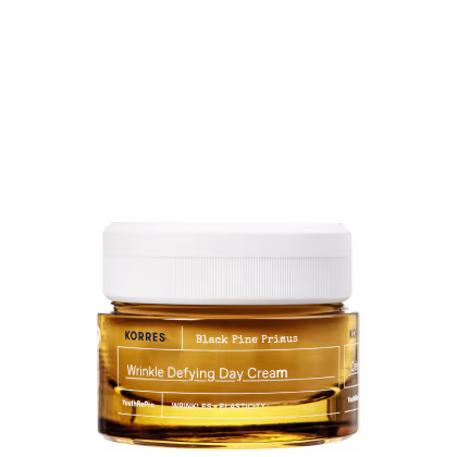 Frasco de creme antienvelhecimento da marca Korres, com rótulo amarelo e branco, contendo a descrição "Wrinkle Defying Day Cream" e "Black Pine Primus".