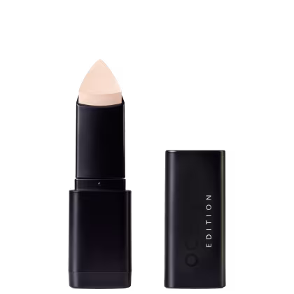 Corretivo em Bastão Océane Concealer Stick. Possui tampa preta e corpo cilíndrico preto liso. Na embalagem, há o texto "EDITION" em letras brancas.