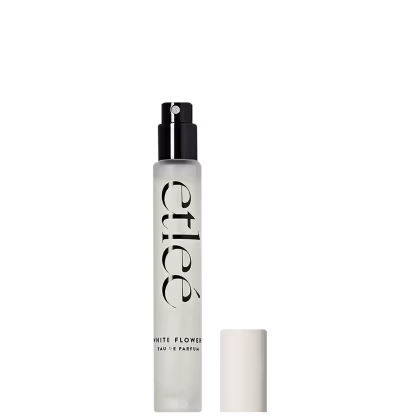 Frasco de perfume Etleé White Flower Eau de Parfum em embalagem transparente, com borrifador preto e com texto em preto destacando o nome da fragrância.
