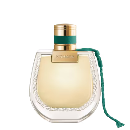 Frasco de perfume dourado com tampa e faixa verde, rótulo com a marca "NOMADE", embalagem de vidro com detalhes em relevo.