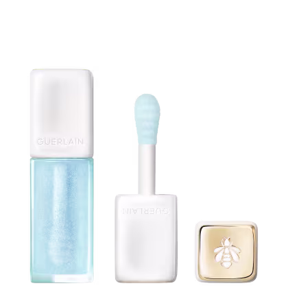 Lip oil da marca Guerlain em tom azul claro com aplicador em formato de esponja, acompanhado de caixa branca com logotipo dourado em forma de abelha.