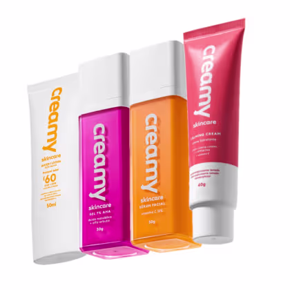 Conjunto de produtos de cuidados com a pele da marca Creamy, incluindo um creme hidratante, um sérum facial, um protetor facial e gel antiacne, em embalagens com cores vibrantes de rosa, laranja e vermelho.