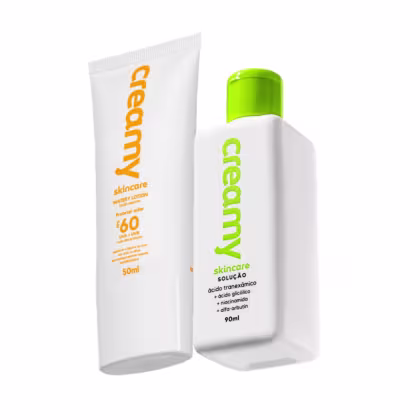 Dois produtos de cuidados com a pele da marca Creamy: um frasco branco com tampa verde contendo Watery Lontion com FPS 60, e um frasco branco com tampa verde contendo solução esfoliante Ácido Tranexâmico