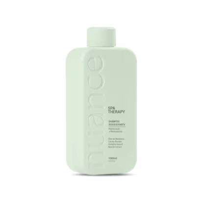 Frasco de shampoo da linha Spa Therapy da marca Nuance Professional.. O produto é descrito como um shampoo sequestante, com ingredientes como óleo de melaleuca, extrato de gengibre e extrato de aloe vera. O frasco possui 1 litro de capacidade.