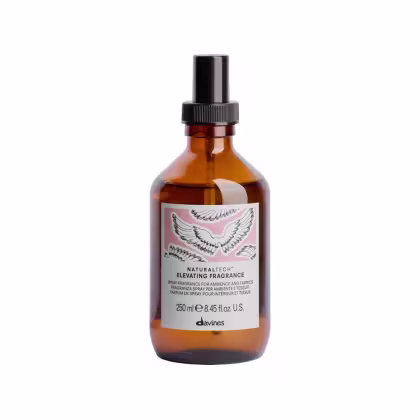 Frasco de spray de fragrância ambiente e tecidos da linha Naturaltech da Davines, com rótulo rosa e branco e imagem de asas estilizadas. Embalagem de 250 ml em vidro âmbar.