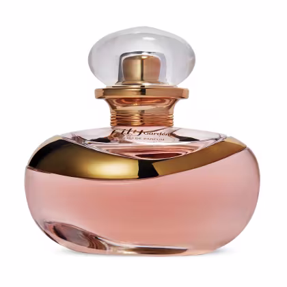 Perfume em frasco de vidro transparente e rosa metálico. O frasco tem formato arredondado com uma tampa esférica transparente. O líquido dentro é rosé gold. O rótulo na parte frontal exibe o nome em letras cursivas.