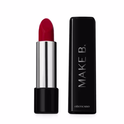 A imagem mostra um batom da marca Make B. O produto é um batom de cor vermelha intensa, com uma embalagem cilíndrica prateada. As cores predominantes são vermelho, preto e prata, criando um visual elegante e sofisticado para o produto de maquiagem.