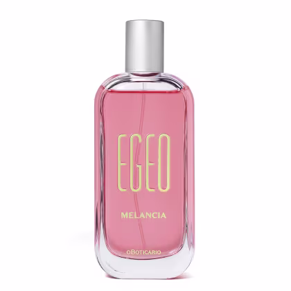 Perfume em frasco retangular de vidro transparente com líquido rosa. Frasco com tampa prateada cilíndrica. Rótulo frontal com o nome "Egeo" em letras douradas e a palavra "Melancia" abaixo em letras menores. Embalagem com cores rosa e verde predominantes.