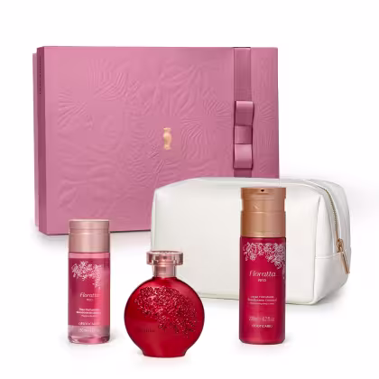 O kit de produtos Floratta apresentado inclui um frasco vermelho com detalhes florais em relevo, um frasco de loção corporal em embalagem rosa e uma bolsa branca. Os itens exibem uma estética com cores e detalhes que remetem a uma fragrância floral.