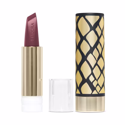 A imagem mostra um close do batom aplicado nos lábios de uma pessoa branca. Os lábios parecem macios e bem delineados, com um acabamento discretamente brilhante. O tom marrom transmite uma aparência sofisticada e elegante.