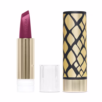 Do lado esquerdo da imagem há a embalagem dourada do produto aberta, desmontada e mostrando a bala do batom. Do lado direito há uma case com design geométrico sofisticado em preto e dourado.
