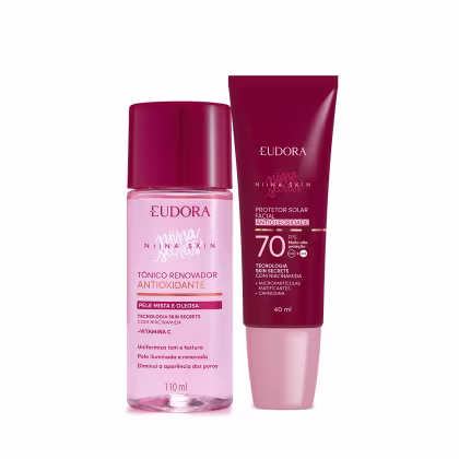 A imagem mostra um kit com dois produtos, lado a lado. Na esquerda, um frasco plástico transparente rosa com tampa vermelha, ao lado de um protetor solar com embalagem toda vermelha e tampa rosa claro.