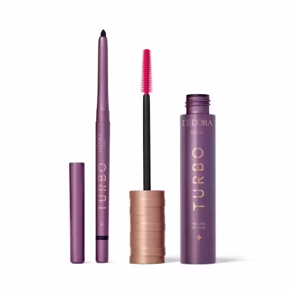 Conjunto de produtos de maquiagem da marca Soul. Inclui um lápis de olhos preto alongado e uma máscara de cílios. As embalagens apresentam detalhes em preto, roxo e dourado.
