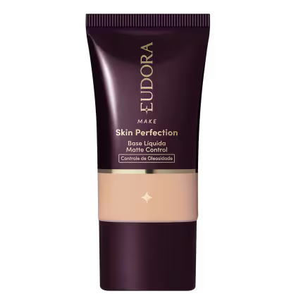 Tubo de base líquida para maquiagem da marca Eudora, com rótulo em tons escuros e dourados, apresentando o nome "Skin Perfection" e informações sobre controle de oleosidade.