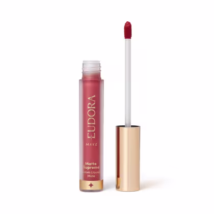 Batom líquido matte de cor vermelha em embalagem plástica transparente com rótulo dourado e branco.