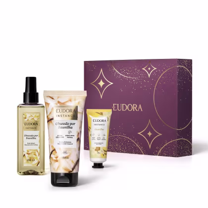 Conjunto de produtos de beleza da marca Eudora, incluindo um body spray, um creme hidratante e um creme para mãos de Instance Obsessão por Baunilha. Com a caixa decorativa com elementos dourados e roxos, indicando ser um kit presente de dia dos namorados.