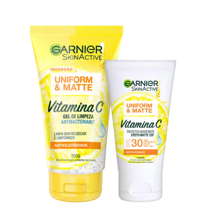 A imagem mostra dois produtos de skincare da linha Garnier Skinactive Uniform & Matte com Vitamina C: um gel de limpeza antibacteriano em tubo amarelo e um protetor hidratante matte com FPS 30 em pote branco.