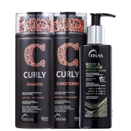 A imagem mostra um shampoo e condicionador da linha "Curly". Os frascos têm um design elegante em preto com detalhes em rosê e padrões ornamentais. Ao lado está um frasco preto de leave-in que possui uma válvula pump com detalhe prata.