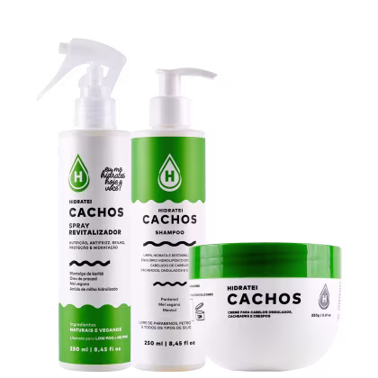 Produtos de cuidados capilares Hidratei Cachos. Dois frascos plásticos de bomba, um branco e um verde, contendo spray revitalizador e shampoo respectivamente. Um pote plástico verde contendo creme para cabelos ondulados, cacheados e crespos.