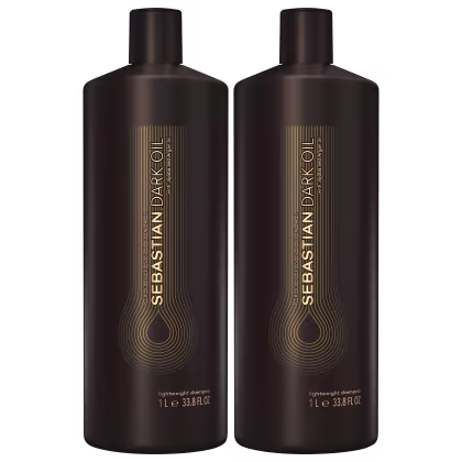 São dois frascos de shampoo leve da marca Sebastian Professional. Os frascos são de plástico marrom escuro e têm formato cilíndrico com tampa preta. Na parte frontal, há o logotipo e nome da marca "Sebastian Dark Oil" em letras douradas.