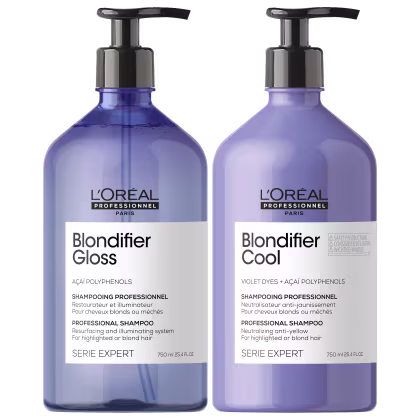 Dois frascos de shampoo profissional da linha Serie Expert da L'Oréal Professionnel Paris. Os frascos são transparentes e têm um design cilíndrico com bombas dosadoras pretas na parte superior.
