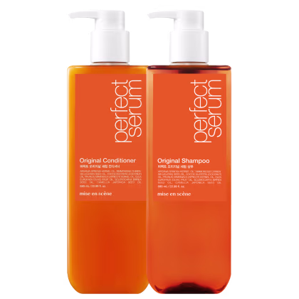 Dois frascos de plástico laranja com bombas brancas, contendo Shampoo Original e Condicionador Original da marca Mise en Scène. Os rótulos exibem informações sobre os ingredientes e a marca.