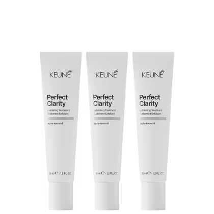 Três tubos brancos da linha Keune Perfect Clarity, um tratamento esfoliante com ácido alfa-cetoacídico. Cada tubo contém 35 ml do produto e apresenta o nome da linha e do ingrediente ativo em destaque.