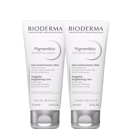 Dois frascos brancos da linha Pigmentbio Sensitive areas da Bioderma, com 75ml cada. Os frascos apresentam rótulos com o nome do produto e informações sobre seu uso para tratar manchas escuras em áreas sensíveis.