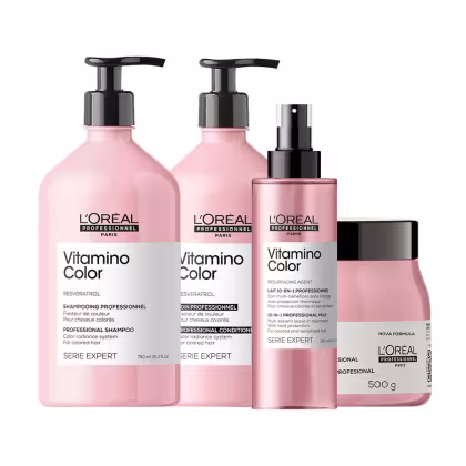 Conjunto de produtos L'Oréal Professionnel da linha Vitamino Color, incluindo shampoo, máscara, condicionador e sérum em embalagens rosa e preta com rótulos indicando os benefícios para cabelos coloridos.