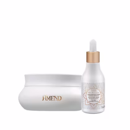 Conjunto de produtos Amend Cosméticos, incluindo um frasco com conta-gotas dourado e uma embalagem branca com detalhes dourados e um padrão decorativo. O rótulo indica tratar-se de um produto de cuidados com a pele.
