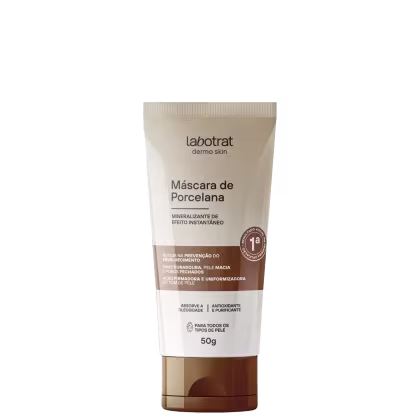 O produto apresentado é uma máscara de porcelana da marca Labotrat, linha Dermo Skin. A embalagem é um tubo de cor bege com rótulo branco e detalhes em marrom. O tamanho do produto é de 50g.