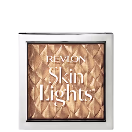 Embalagem quadrada, transparente com bordas prateadas. Nome da linha escrito em letras brancas. É possível ver o produto através da transparência, tem uma cor dourada com padrões em losango.