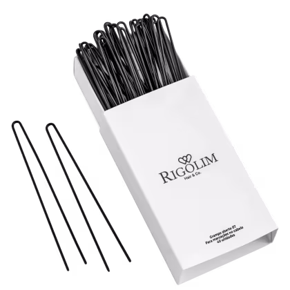 Grampos para cabelo da marca Rigolim Hair & Co. A embalagem é uma caixa branca com o logotipo e nome da marca impressos em preto. O conteúdo da caixa é um conjunto de grampos de cabelo pretos, que estão dispostos de forma organizada dentro da caixa.