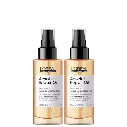 Dois frascos de óleo reparador Absolut Repair Oil da linha Serie Expert da L'Oréal Professionnel. Os frascos são de plástico transparente com tampa preta fosca. O rótulo indica que é um óleo de gérmen de trigo 10 em 1. O volume é de 90 ml