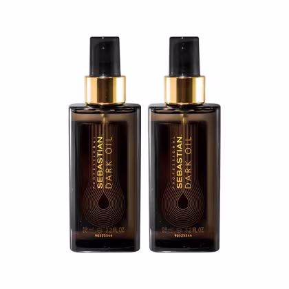 A imagem mostra dois Óleos Capilares Dark Oil da marca Sebastian Professional. Os frascos são pretos, com detalhes em dourado. Apresentam o logotipo e nome da marca "Sebastian Dark Oil" em letras douradas estilizadas.