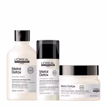 Três produtos da linha Metal Detox da L'Oréal Professionnel. Um shampoo. Um creme e uma máscara em um pote branco com detalhes pretos. Todas as embalagens têm o logotipo da L'Oréal Professionnel e a inscrição "Metal Detox" em letras pretas