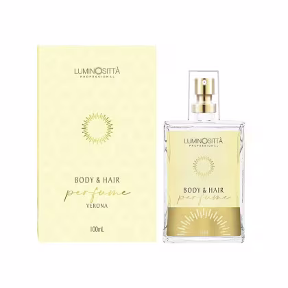 Apresenta uma embalagem retangular branca que contém um frasco de vidro amarelo claro com detalhes dourados, com pulverizador dourado na parte superior. Ao lado está a caixa do produto, também na cor branca.