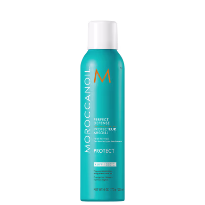 A imagem mostra o Protetor Térmico Moroccanoil Perfect Defense 225ml, com frasco cilíndrico na cor azul turquesa e detalhes em laranja e branco. O texto destaca que o produto oferece proteção térmica de até 450°F/230°C.