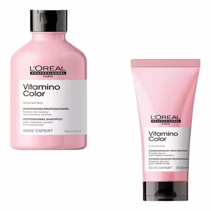 A imagem mostra dois produtos de cuidados capilares da linha Vitamino Color da L'Oréal Professionnel. Um é um shampoo em um frasco plástico rosa de 300ml e o outro é um condicionador em um tubo rosa de 200ml.