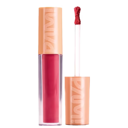 A imagem mostra o batom líquido matte de Pam by Pamella. Seu tubinho é transparente e mostra a cor rosa avermelhada do batom. Ao lado tem a tampa laranja com a logo PAM! escrita e o bastão com uma ponta de aplicador em formato de ampulheta.