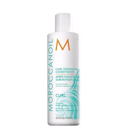 Frasco branco de condicionador Moroccanoil para realçar cachos, com rótulo em branco e laranja exibindo o nome da marca e a descrição "Curl Enhancing Conditioner".