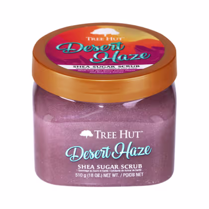 Pote de esfoliante corporal da Tree Hut, com rótulo laranja e roxo destacando o nome do produto e a descrição "Shea Sugar Scrub".