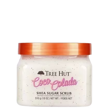 Pote de vidro com tampa laranja contendo um produto de esfoliação corporal da marca Tree Hut, com o nome "Cocoa Colada" e a descrição "Shea Sugar Scrub" impressos no rótulo.