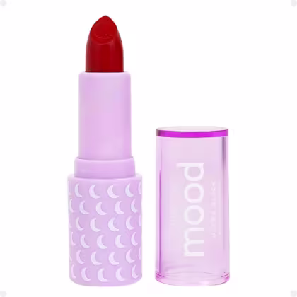 Batom vermelho da marca Ruby Rose. A embalagem é composta por um tubo de batom com uma tampa lilás, que exibe um padrão de luas brancas. O rótulo do produto está visível, com o nome da marca "Ruby Rose" impresso em letras brancas.